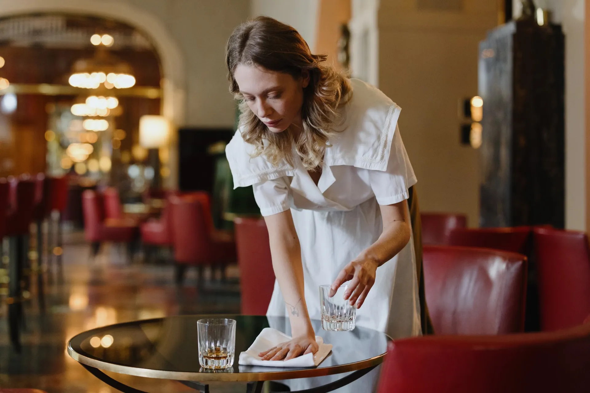 Een serveerster dekt een tafel voor de service (illustratiefoto)